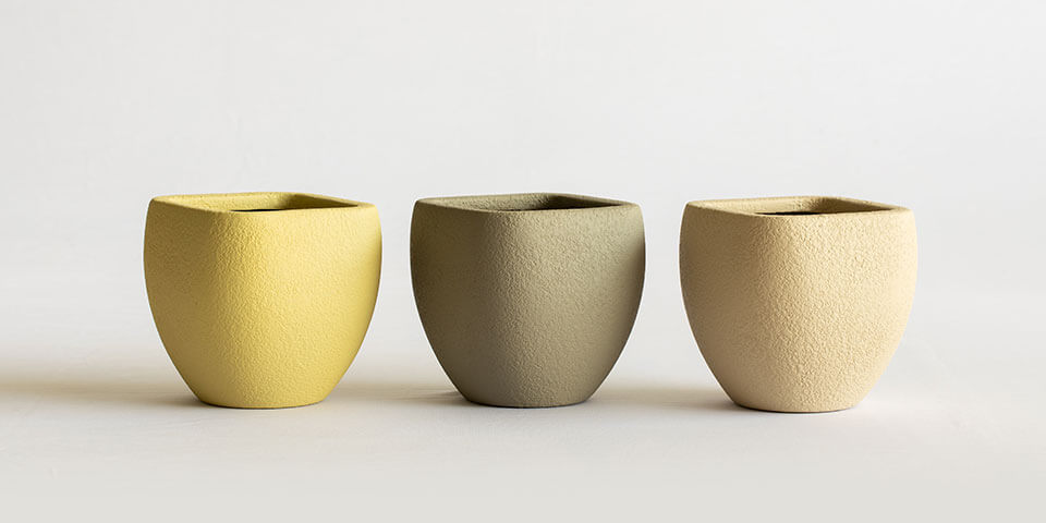 3 tabletop planters in rustic finish in yellow, grey and buff color placed besides each other
